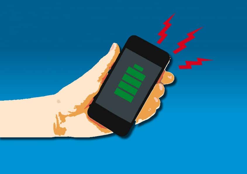 Une main tenant un téléphone portable alimenté au lithium-ion avec un symbole d'éclair dessus.
