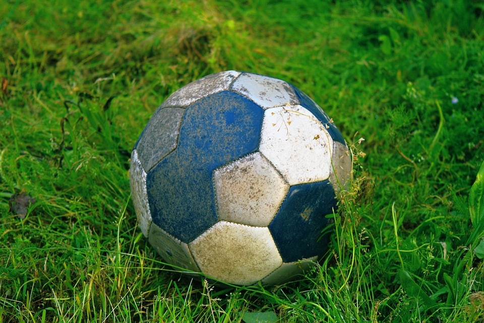 Un ballon de football reposant dans l'herbe.