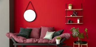Une chambre à coucher avec des murs rouges et un canapé rose.