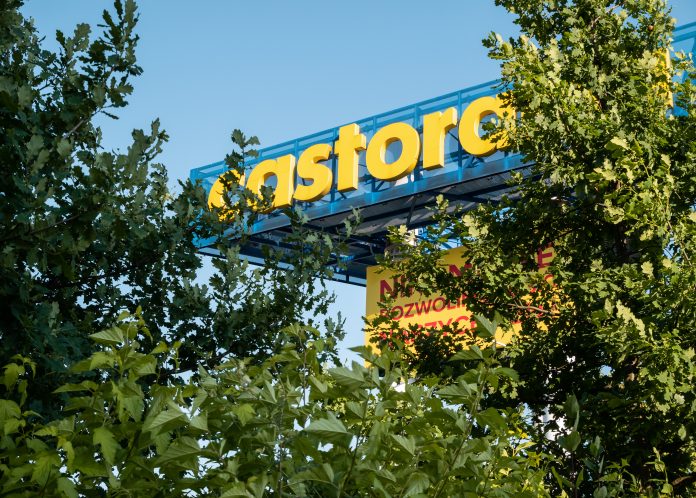 Une pancarte bleue et jaune avec un arbre en arrière-plan faisant la promotion de l'alternative écologique et économique granulés de bois de Castorama.