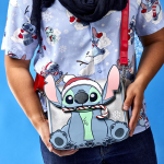Une femme tient un sac bandoulière Loungefly.
