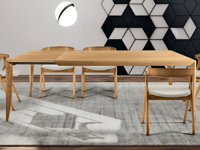 Une table à manger et des chaises modernes dans une pièce monochrome.