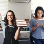 Deux femmes confortables lisant des livres dans la cuisine.