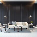 Salon moderne avec murs sombres, canapé blanc, fauteuils, suspensions et décoration contemporaine.
