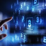 Une main se tend vers une interface numérique affichant plusieurs symboles Bitcoin sur fond bleu, représentant la technologie des cryptomonnaies et l'évolution rapide des systèmes financiers, à l'image du caractère innovant de Brouillon auto.