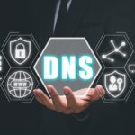 Une personne en costume tient une image graphique affichant le terme « DNS » dans un hexagone, entourée d'icônes représentant la sécurité Internet, la connectivité et les données. La présentation soignée contraste fortement avec les esquisses initiales du brouillon.