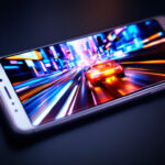 Un smartphone affichant un jeu vidéo de course – l'un des incontournables des jeux mobiles – avec une voiture de sport filant à travers un paysage urbain coloré et éclairé au néon.